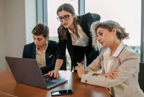 צוות מקצועי עובד יחד סביב מחשב נייד – שיתוף פעולה עסקי ושותפות בינלאומית<br />